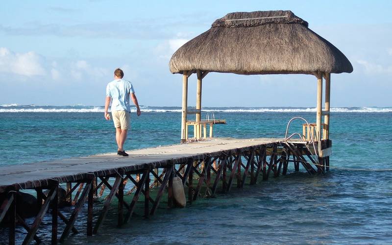 Man walking along sea shore in Mauritius