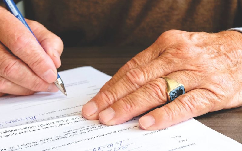 A man writing a visa application letter.
